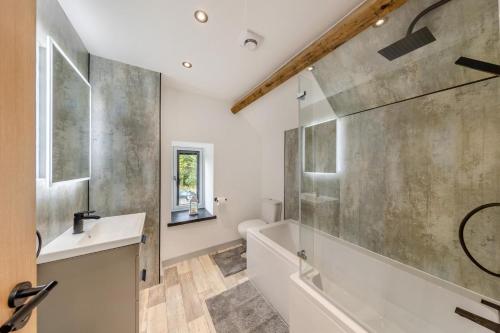 a bathroom with a tub and a sink and a shower at 2 Bed in Penmaenpool oc-m30050 in Arthog