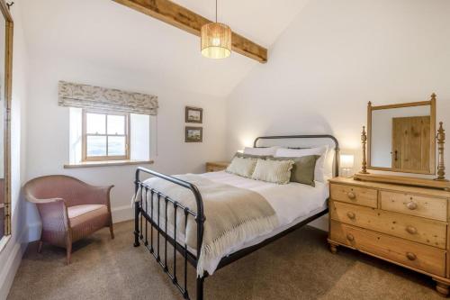 a bedroom with a bed and a mirror and a chair at 2 Bed in Cowling oc-l30774 in Cowling