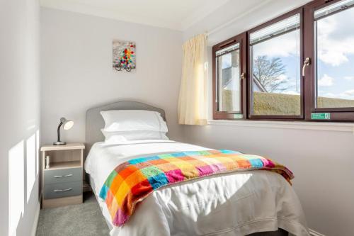 a bedroom with a rainbow blanket on a bed at 2 Bed in Insch oc-t30986 in Colpy