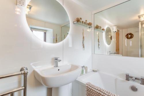 a white bathroom with a sink and a mirror at 3 Bed in Isle Of Skye oc-r31786 in Broadford