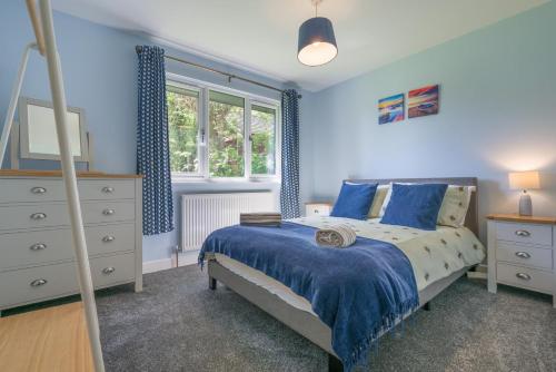 a bedroom with blue walls and a bed and a dresser at 2 Bed in Bush oc-b31845 in Bude
