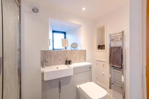 a white bathroom with a toilet and a sink at 1 Bed in Austwick oc-b31906 in Horton in Ribblesdale