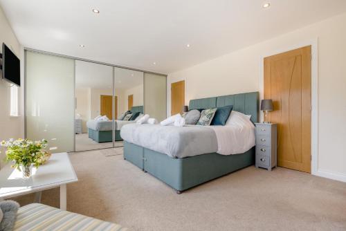 a bedroom with a large bed and a large mirror at 5 Bed in Bradworthy oc-d31987 in Bradworthy