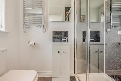 a white bathroom with a shower and a toilet at 5 Bed in Bradworthy oc-d31987 in Bradworthy