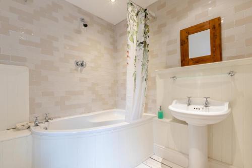 a bathroom with a sink and a tub and a toilet at 3 Bed in Ilminster oc-b32054 in Barrington