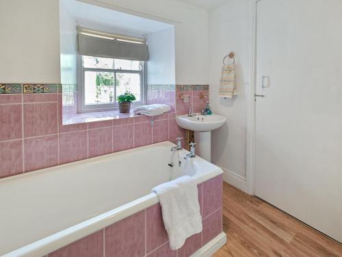 a pink bathroom with a tub and a sink at 1 Bed in Corbridge oc-t31977 in Corbridge