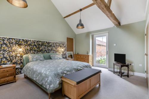 a bedroom with a large bed and a tv at 2 Bed in Barton Turf oc-i29127 in Neatishead