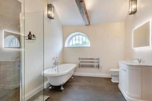a bathroom with a tub and a sink and a toilet at 2 Bed in Barton Turf oc-i29127 in Neatishead