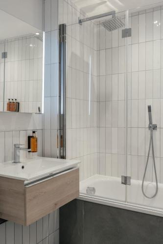 a bathroom with a shower and a tub and a sink at Urban Rest Camden Town in London