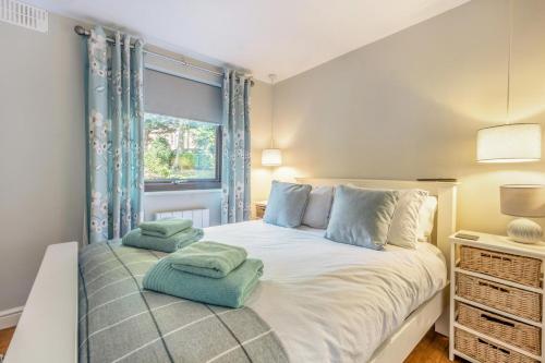 a bedroom with a large white bed with blue pillows at 2 Bed in Weybourne oc-2151 in Weybourne