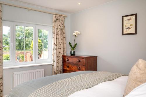 a bedroom with a bed and a dresser and a window at 2 Bed in Beccles oc-rilo in Beccles