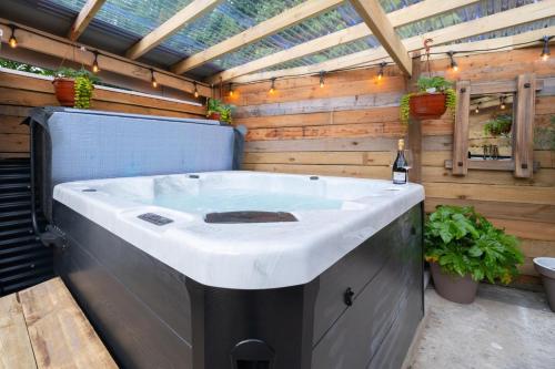 a large bath tub in a patio with a wooden wall at 2 Bed in Aberaeron oc-bow329 in Aberaeron