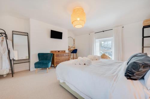 a bedroom with a white bed and a blue chair at 2 Bed in Aberaeron oc-bow329 in Aberaeron