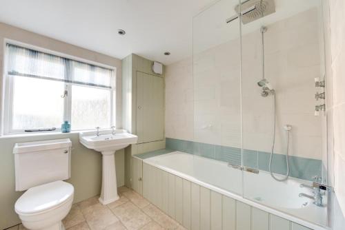 a bathroom with a tub and a toilet and a sink at 4 Bed in Southwold oc-30vs in Southwold