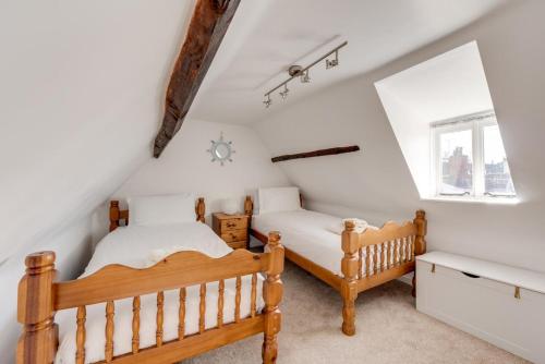 a attic bedroom with two beds and a window at 4 Bed in Southwold oc-30vs in Southwold