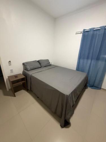 a bedroom with a bed with a blue curtain at Pipa House Center in Pipa