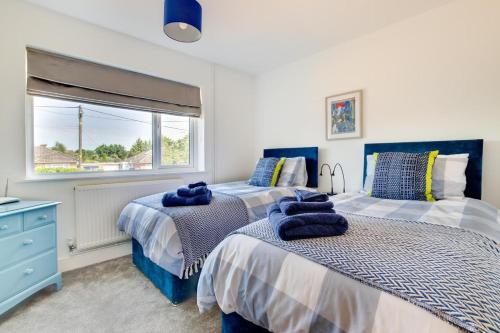 a bedroom with two beds and a window at 4 Bed in Reydon oc-lxw in Reydon