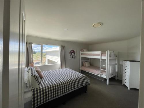 a bedroom with two bunk beds and a window at Hydrabad Views in Waitarere