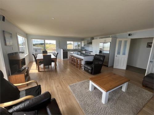 a living room with a couch and a table at Hydrabad Views in Waitarere
