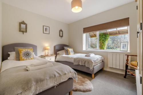 a bedroom with two beds and a window at 3 Bed in Staplecross oc-rh1162 in Sedlescombe