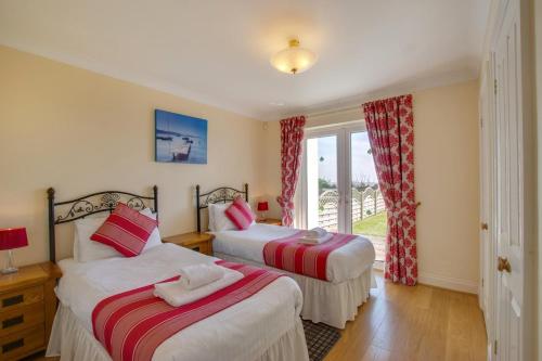 a bedroom with two beds and a window at 4 Bed in Gower oc-hh9906 in Port-Eynon