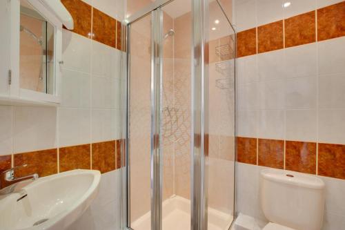 a bathroom with a shower and a sink and a toilet at 4 Bed in Gower oc-hh9906 in Port-Eynon