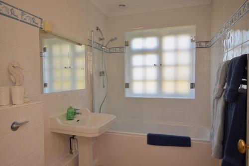 a white bathroom with a sink and a tub and a shower at 1 Bed in Tenterden oc-tn623 in Saint Michaels