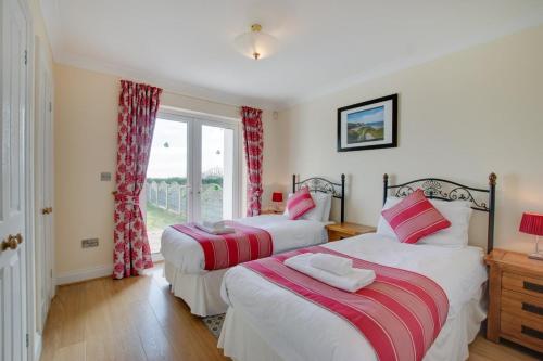 two beds in a room with a window at 4 Bed in Port Eynon oc-hh9905 in Port-Eynon