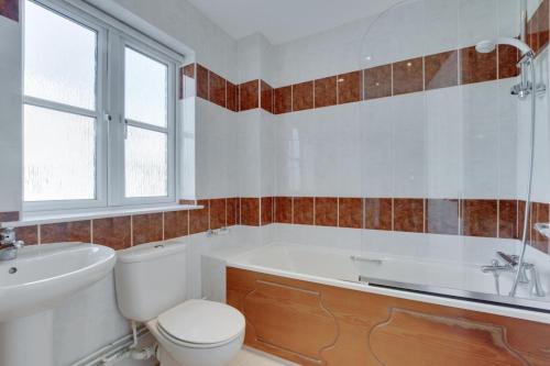 a bathroom with a tub and a toilet and a sink at 4 Bed in Port Eynon oc-hh9905 in Port-Eynon