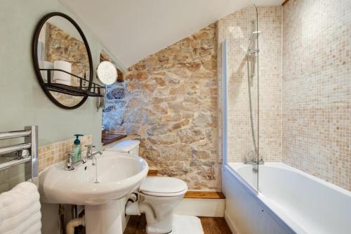 a bathroom with a sink and a toilet and a tub at 2 Bed in Middleton-by-Youlgrave oc-dchol7 in Middleton