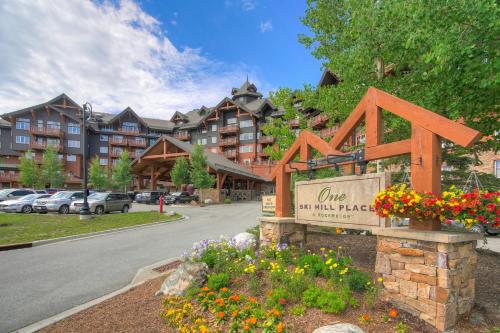 a sign in front of a apartment building with flowers at One Ski Hill Place, a RockResort, by Vail Resorts in Breckenridge
