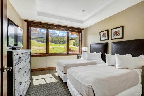 a hotel room with two beds and a television at One Ski Hill Place, a RockResort, by Vail Resorts in Breckenridge
