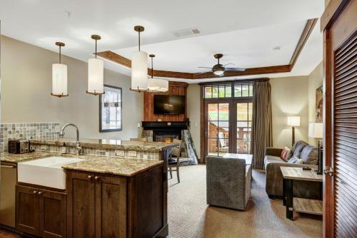 a kitchen with a sink and a living room at One Ski Hill Place, a RockResort, by Vail Resorts in Breckenridge