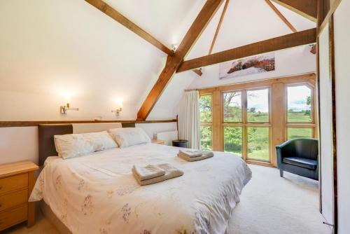 a bedroom with a bed with a chair and a window at 2 Bed in Meshaw oc-meadow in Meshaw