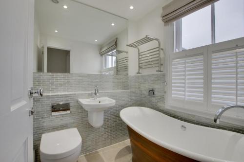 a bathroom with a tub and a sink and a toilet at 2 Bed in Fowey oc-forty in Fowey