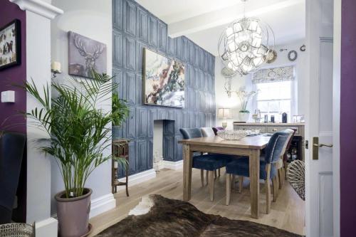 a dining room with a table and blue chairs at The Town House BnB in Brecon