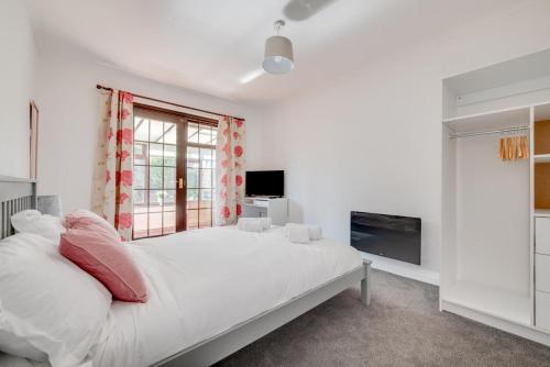 a white bedroom with a large bed and a window at 2 Bed in Seahouses oc-nb1974 in North Sunderland