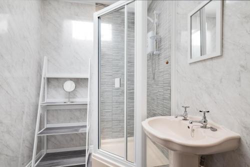 a white bathroom with a sink and a shower at 2 Bed in Seahouses oc-nb1974 in North Sunderland