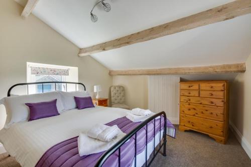 a bedroom with a large bed and a wooden dresser at 4 Bed in Gayle oc-ds950 in Hawes