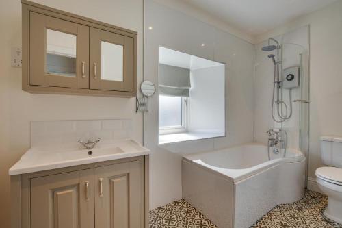 a bathroom with a tub and a sink and a toilet at 4 Bed in Gayle oc-ds950 in Hawes
