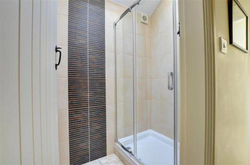 a shower with a glass door in a bathroom at 2 Bed in Menai Bridge oc-fl046 in Llandegfan