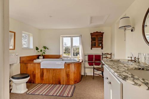 a bathroom with a tub and a toilet and a sink at 6 Bed in Wymondham oc-t30598 in Wymondham