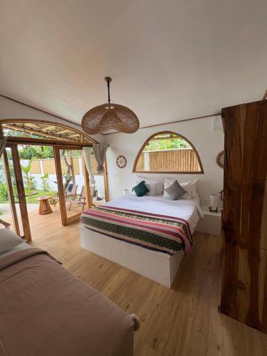 a bedroom with a bed and a large window at You & Me Private Villa in Gili Islands
