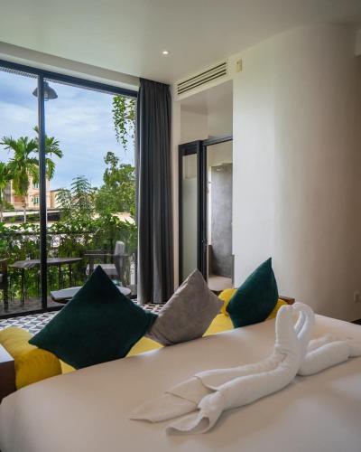 a bedroom with a large bed and a large window at Villa Sun - Boutique Hotel in Siem Reap