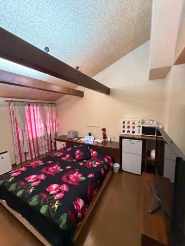 a bedroom with a bed with pink flowers on it at ホテルプチハウス大人専用 in Barajima