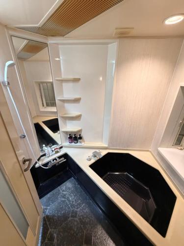 a small kitchen with a sink and a counter at ホテルプチハウス大人専用 in Barajima