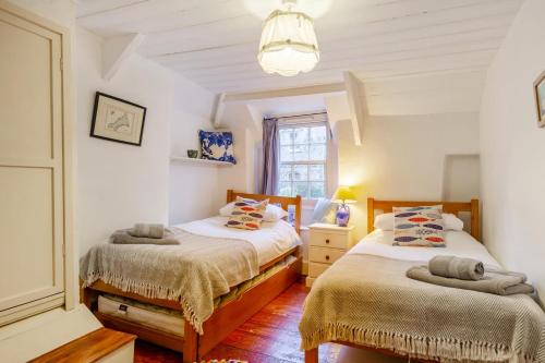 a bedroom with two beds and a window at 5 Bed in Little Petherick oc-melynw in Little Petherick
