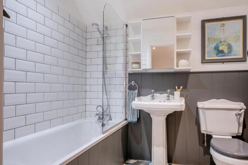 a bathroom with a sink and a tub and a toilet at 3 Bed in Chale oc-s30298 in Chale
