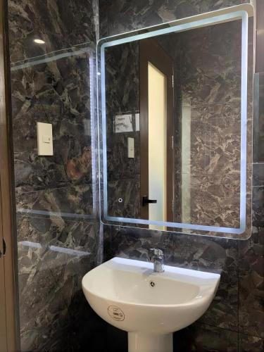 a bathroom with a sink and a mirror at Lindelle Place Palawan in Puerto Princesa City