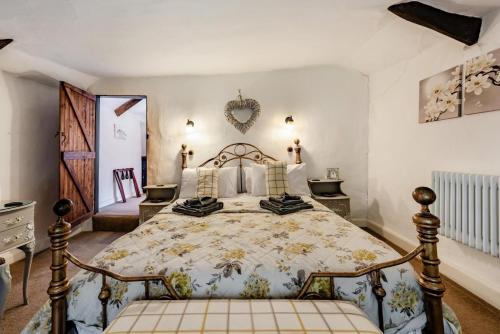 a bedroom with a large bed with a floral bedspread at 2 Bed in Broadwoodkelly oc-j31818 in Broadwoodkelly